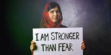 Malala holding a poster:I am stronger than fear