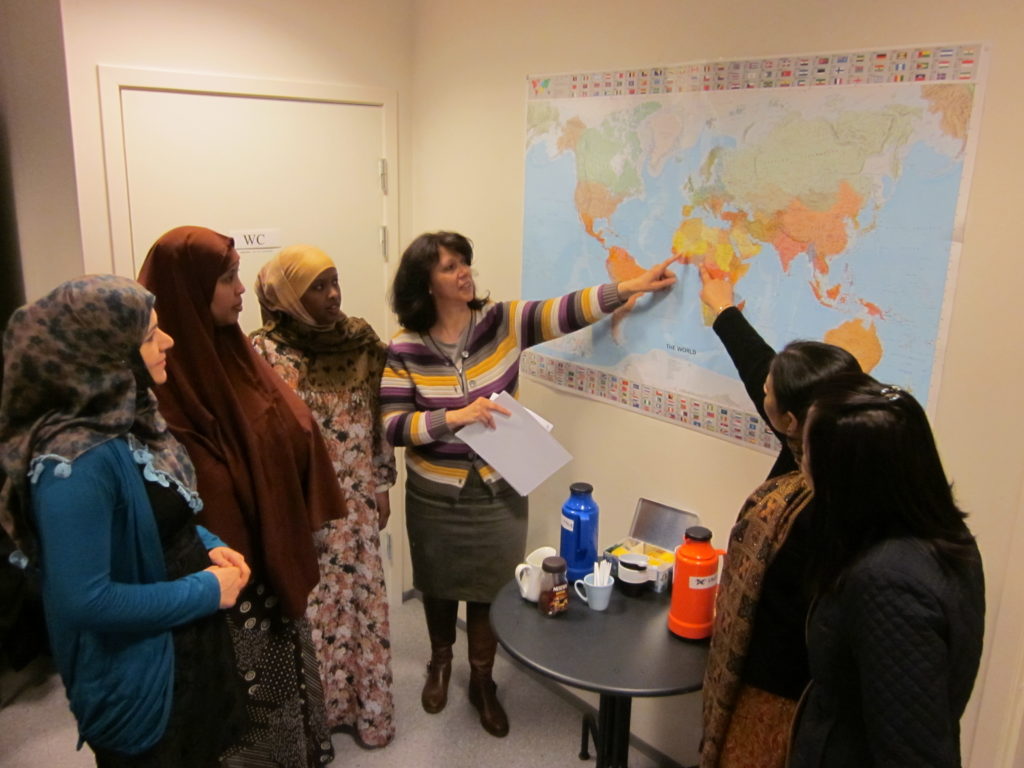 Deltakere på språkkafé ser på verdenskartet.
