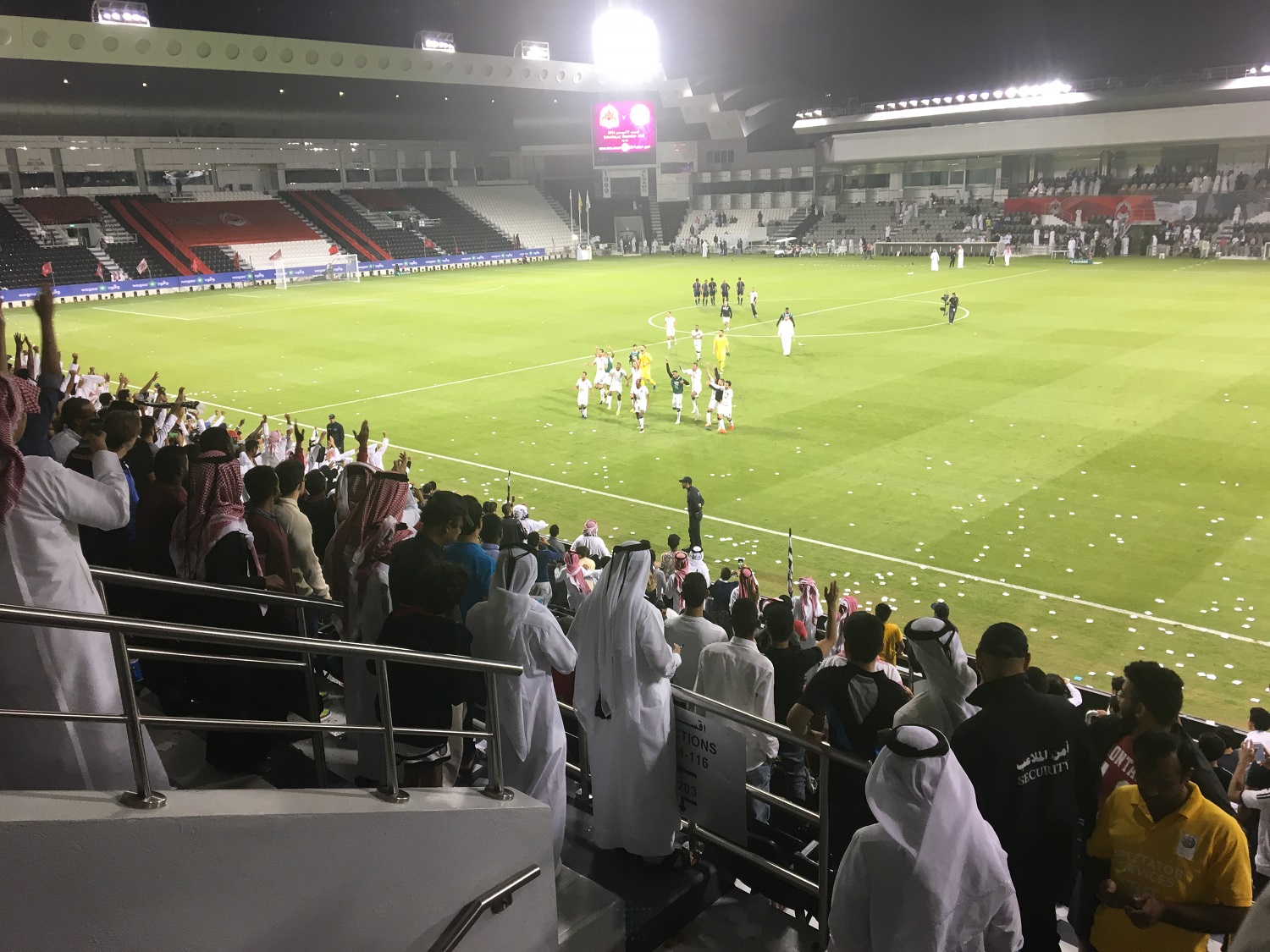Fotballkamp i Qatar. Bildet viser tribunen og et lag som takker fansen etter kamp.