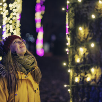 Jente ser på julelys i park