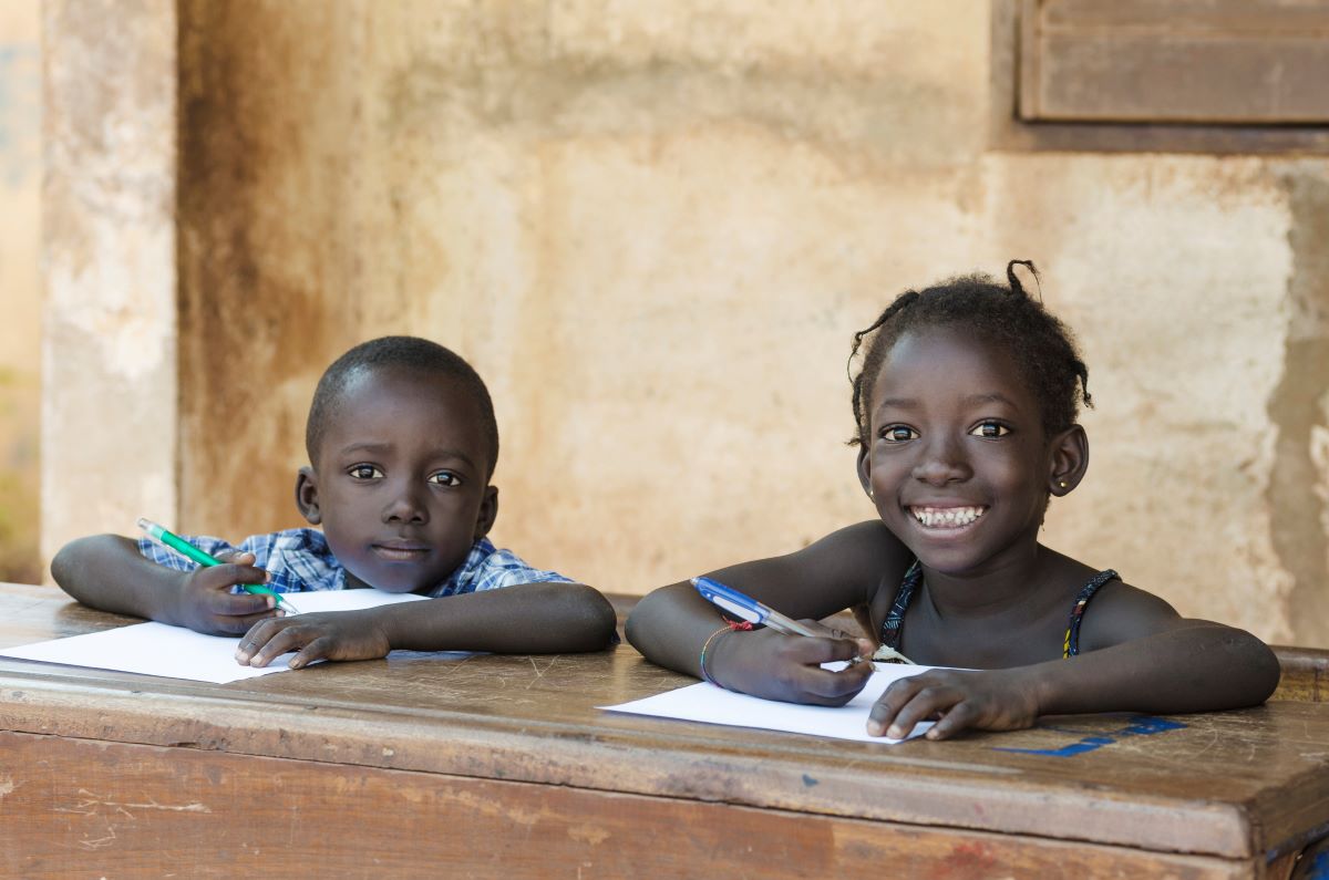 En gutt og ei jente sitter ved en skolepult. 